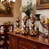 chess piece decor on sideboard with vases and flowers