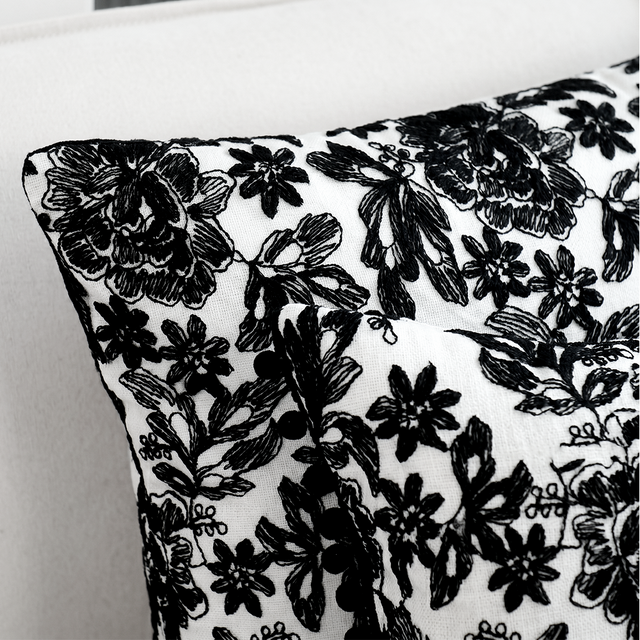 close up of pom pom trim on black floral pillow
