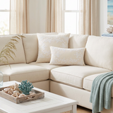 cream embroidered pillows on cream sectional with shells