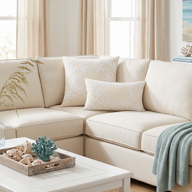 cream embroidered pillows on cream sectional with shells