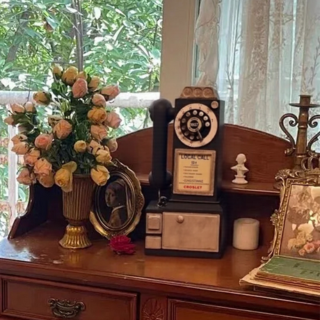 distressed resin decorative desk phone on a painted desk