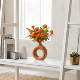 donut vase with orange flowers on shelf