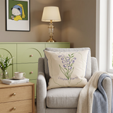 embroidered lily pillow on grey armchair with lamp