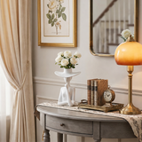 figure vase with roses on console table