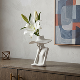 figure vase with white lily on sideboard