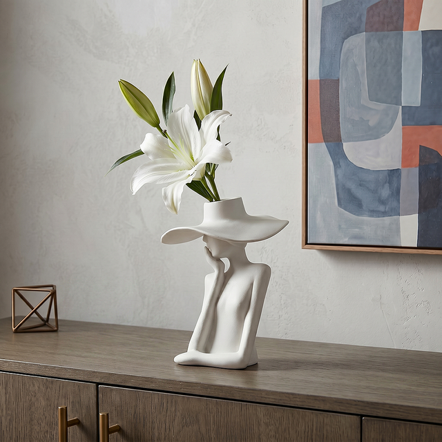 figure vase with white lily on sideboard