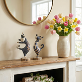 figurines standing cats on fireplace mantel flowers