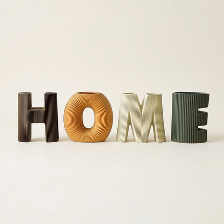 four letter ceramic home vases on beige