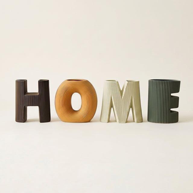 four letter ceramic home vases on beige