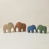 four minimalist wooden elephant figurines