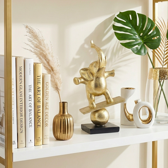 gold balancing elephant on white shelf with books