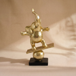 gold balancing elephant sculpture on stand