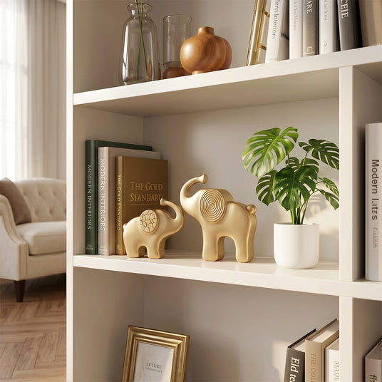 gold elephant sculptures on white bookshelf