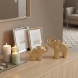 gold elephant sculptures on wooden sideboard