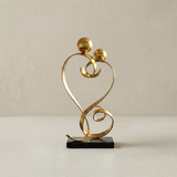 gold love sculpture on black marble base