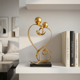 gold love sculpture on white shelf books