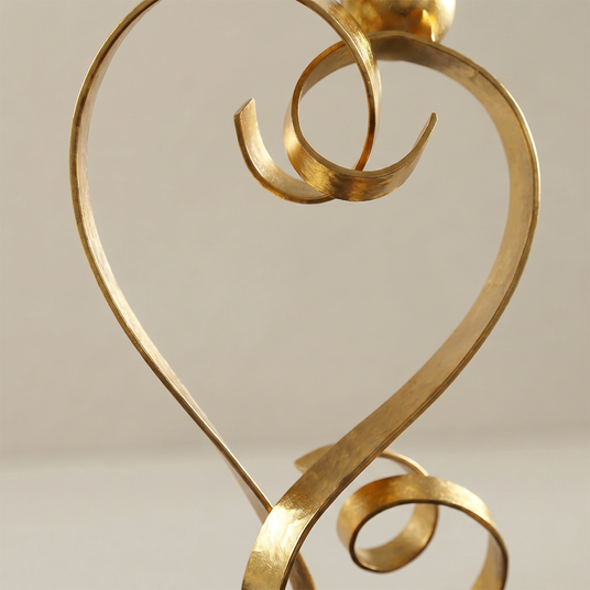 gold love sculpture ribbon curves close up