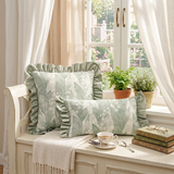 green ruffle pillows on window seat with tea
