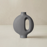grey ceramic vase with central cutout on neutral background
