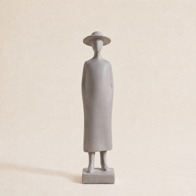 grey figurine wearing dress on neutral background