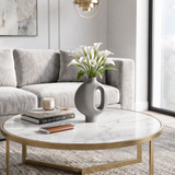 grey vase with white calla lilies on marble table