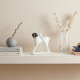 horse and rider sculpture on beige shelf with vases