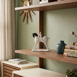 horse and rider sculpture on wooden shelf with books