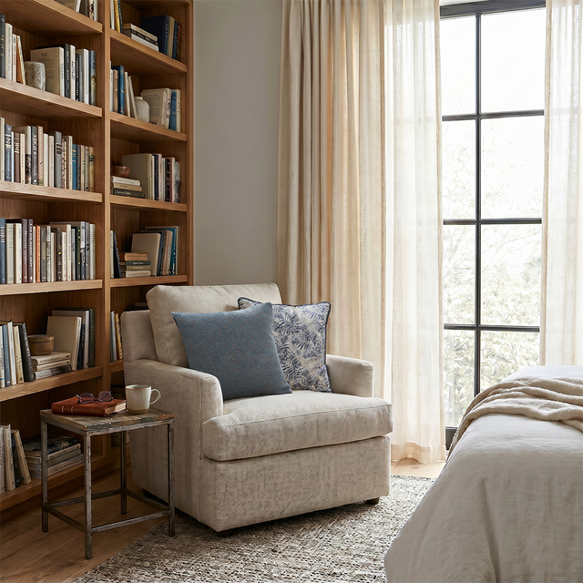 jacquard pillows on beige armchair by bookshelf