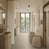 large gray foldable laundry basket with easy carry handles in the bathroom