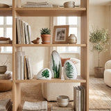 leaf print ceramics on wooden shelf with books