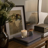 leather jewelry storage box placed underneath photo frame and candles