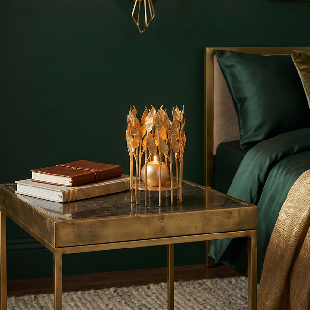 lit gold leaf candle holder on bedside table