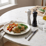 marble salt and pepper mills on dining table with meal