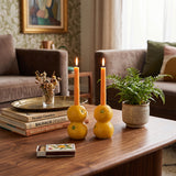 orange candle holders behind stacked books