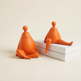 orange figurines beside white books