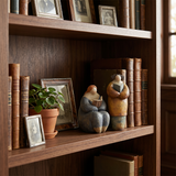 pebble figurines on bookshelf with books