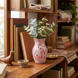 pink mosaic vase with berries on wooden shelf