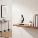 sailboat sculpture on floating wooden shelf