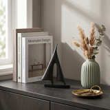 sailboat sculpture on table with frame and vase