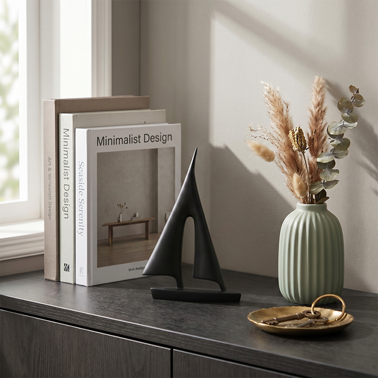 sailboat sculpture on table with frame and vase