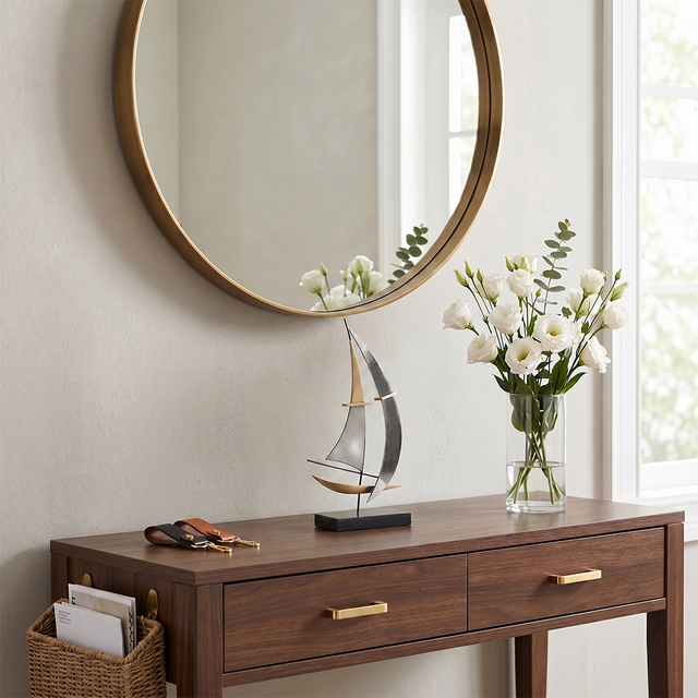 sailboat sculpture on wooden console with mirror