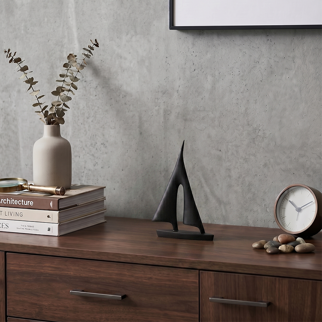 sailboat sculpture with plant on wooden cabinet