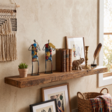 sculptures on rustic wooden shelf with books