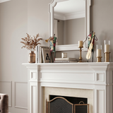 sculptures on white mantel candles books