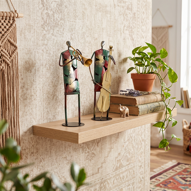 sculptures on wooden shelf plant books