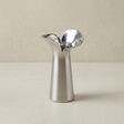 silver flower shaped metal vase on beige