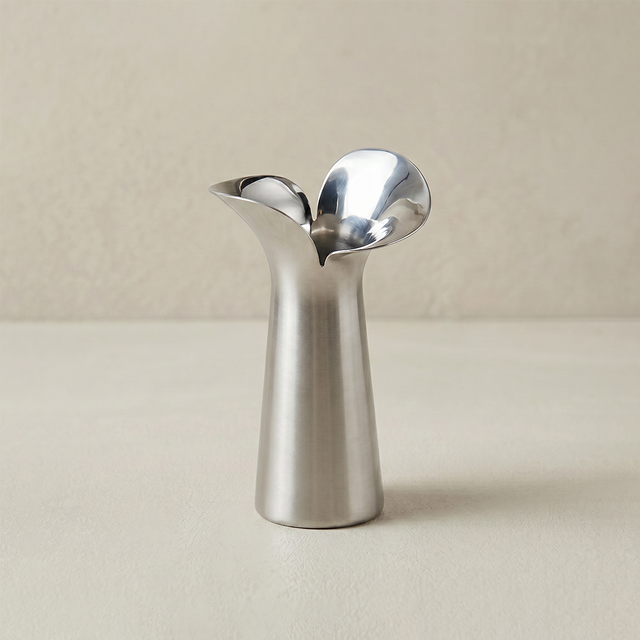 silver flower shaped metal vase on beige