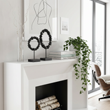 stone ring sculptures on modern mantel