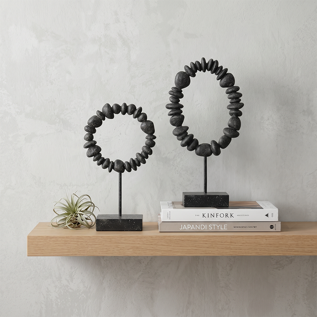 stone ring sculptures on wooden shelf