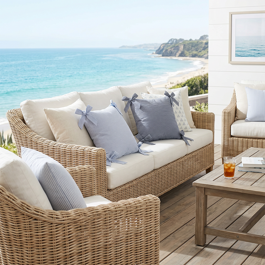 striped bow pillows on coastal patio wicker sofa